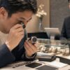 オーバーホール済み中古時計の整備明細と保証を確認する日本人男性