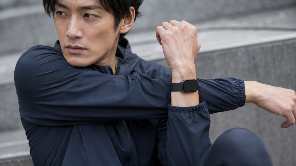 薄く軽いスマートウォッチを着けてストレッチする日本人ランナー
