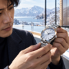 日本人の時計愛好家が自然を思わせる無銘の高級時計を光の下で確認するイメージ